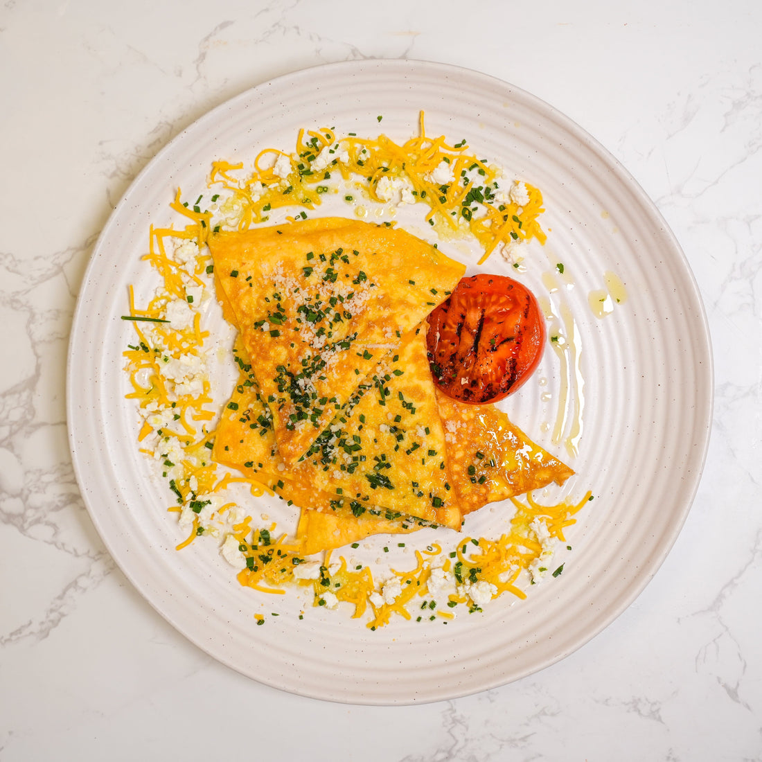 Bozu breakfast omelette with tomatoes, grated cheese, and fresh garnish served on a plate for under £5.00