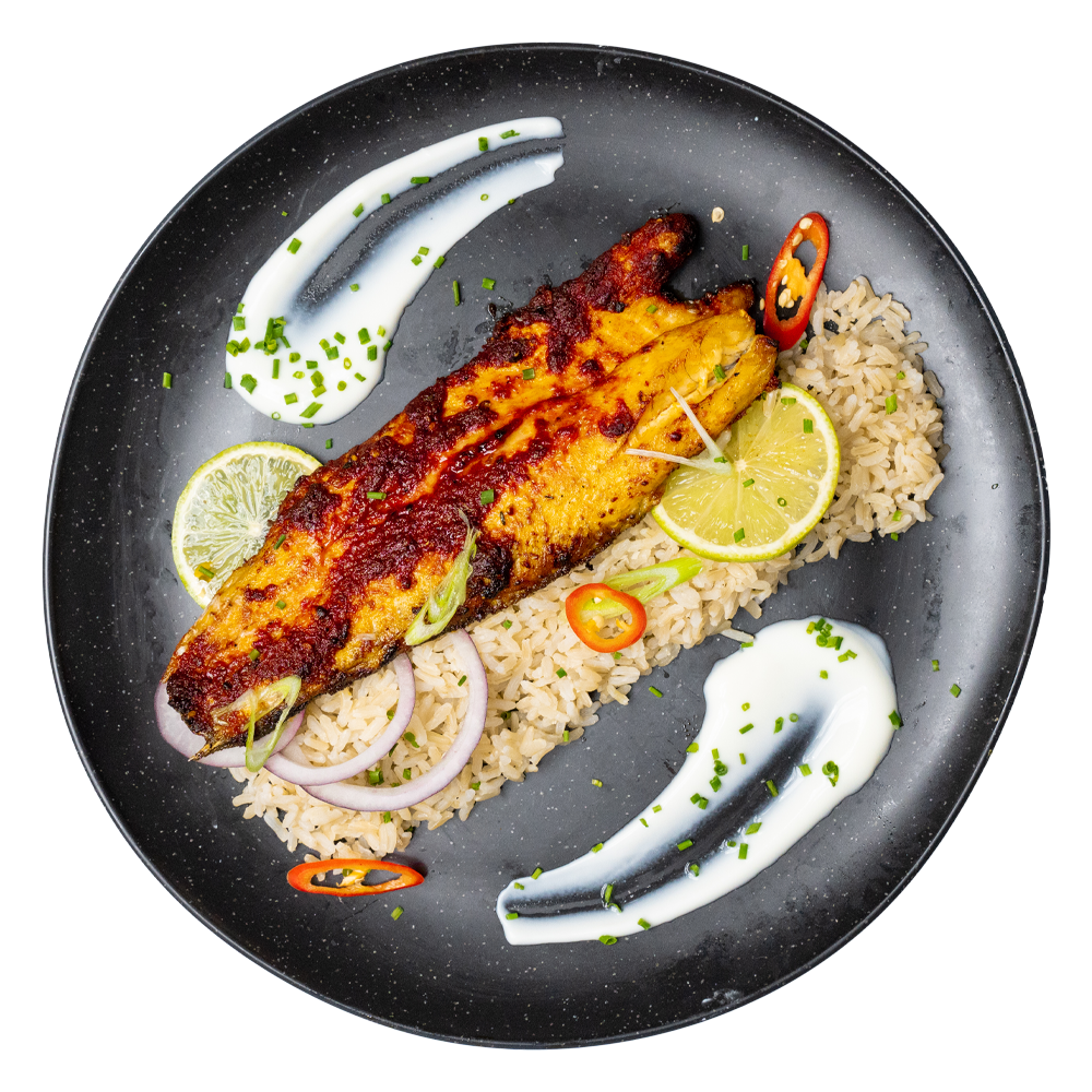Fresh chef-prepared fish with rice, lemon, and onions delivered for workplace lunches in the UK by Bozu, part of healthy office meal delivery plans