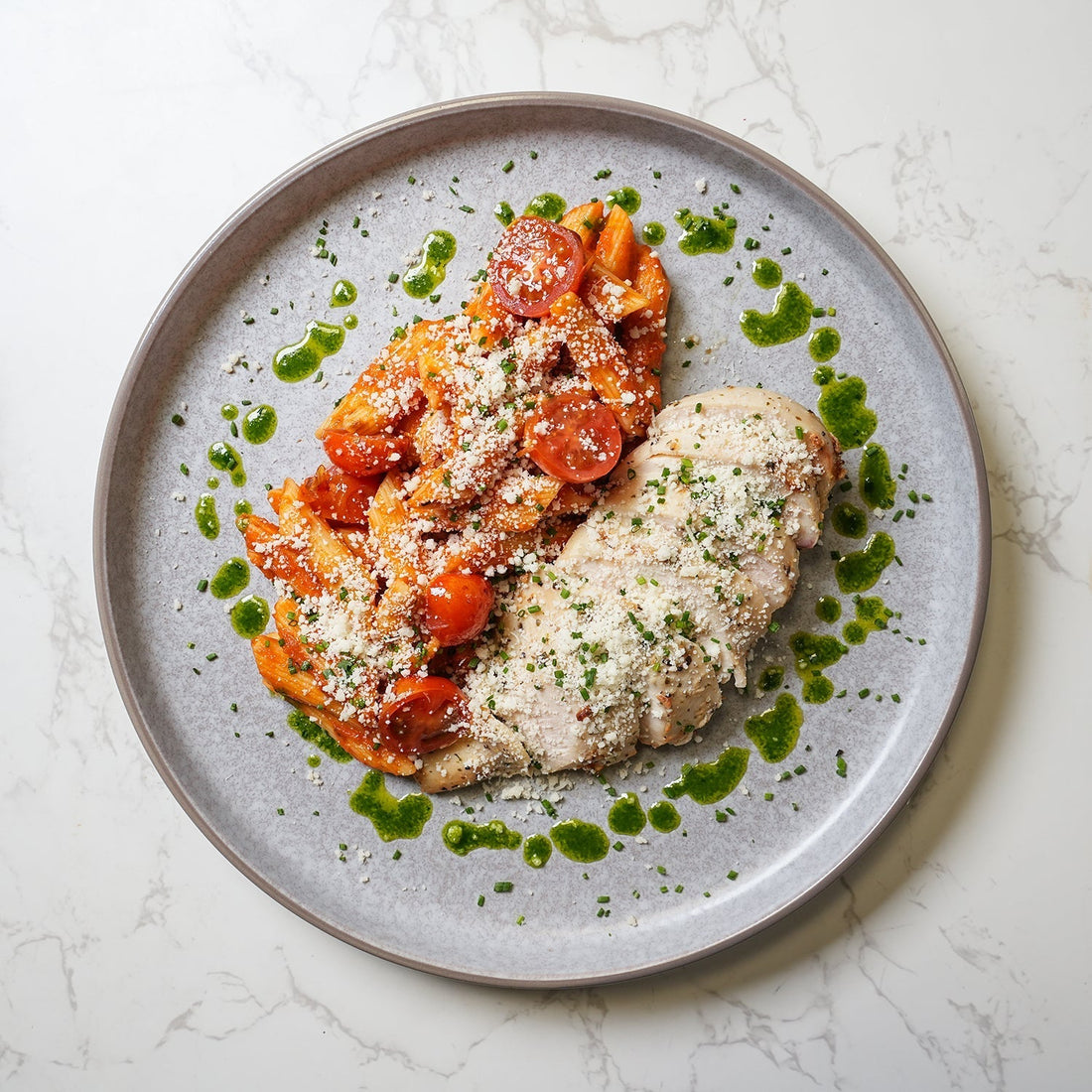 BOZU healthy family meal with grilled chicken breast, tomato penne pasta and cherry tomatoes, showcasing nutritious ready meals for large families in the UK