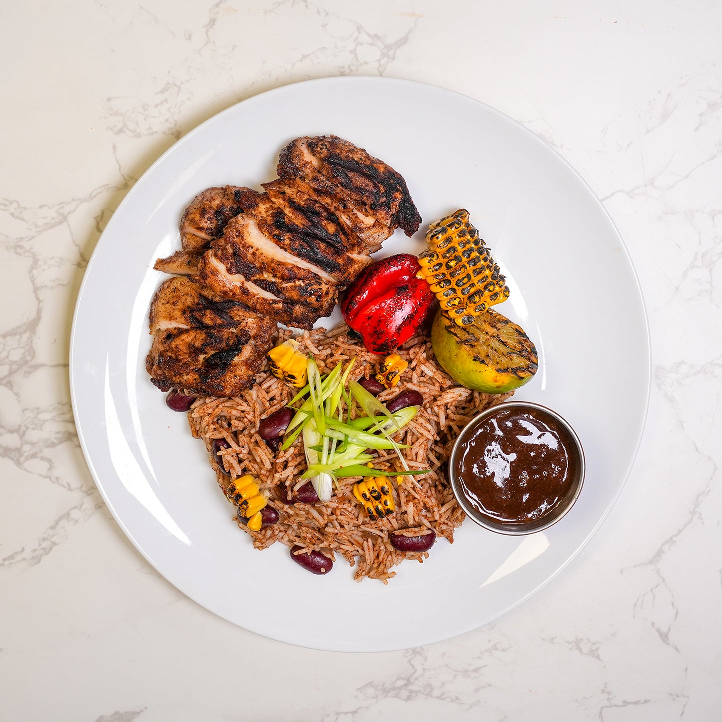 Caribbean jerk chicken thighs with rice and peas, charred corn cobette and jerk onion gravy – high protein meal prep by Bozu UK
